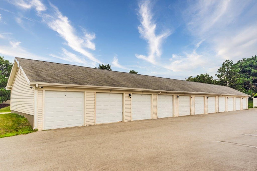 a row of white garages with white doors and a roof