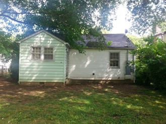 the back of the house with the yard in front of it