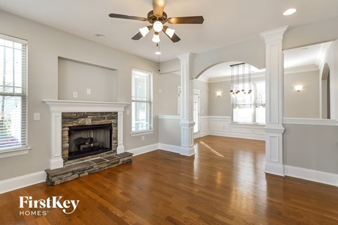 A spacious room with a fireplace and a ceiling fan.