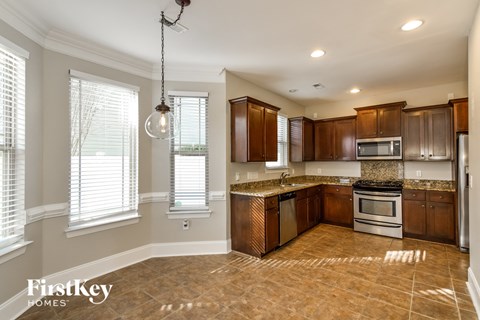 A kitchen with brown cabinets and a tile floor.