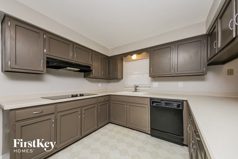 A kitchen with brown cabinets and a black oven.