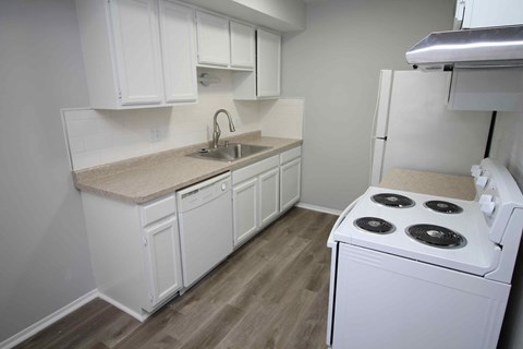 A white kitchen with a stove and sink.