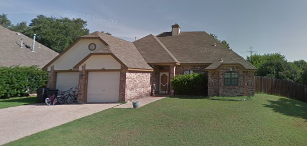 a brick house with a garage and a lawn