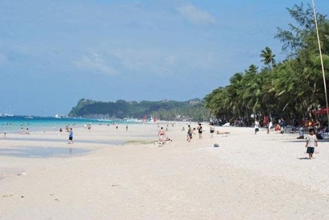 a beach with many people on it and the ocean