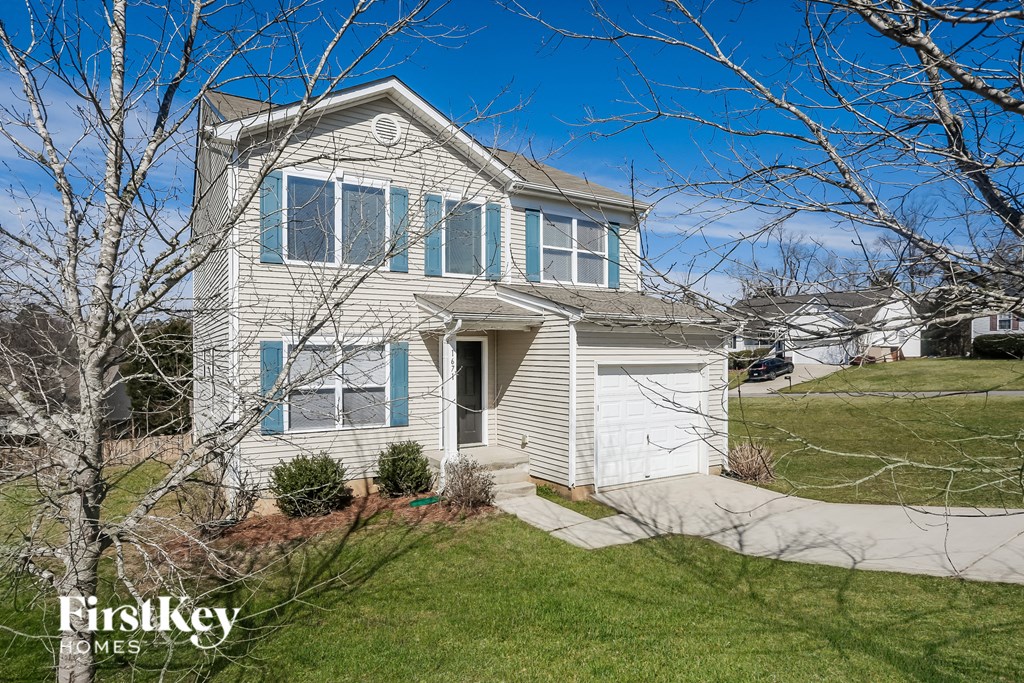 A house with a garage and a driveway in front of it.