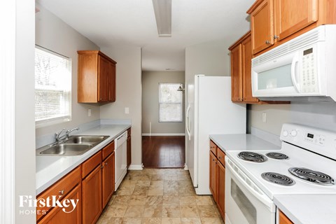 A kitchen with wooden cabinets and white appliances.
