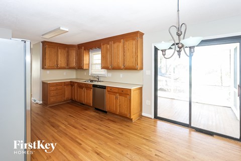 A kitchen with wooden cabinets and a refrigerator.