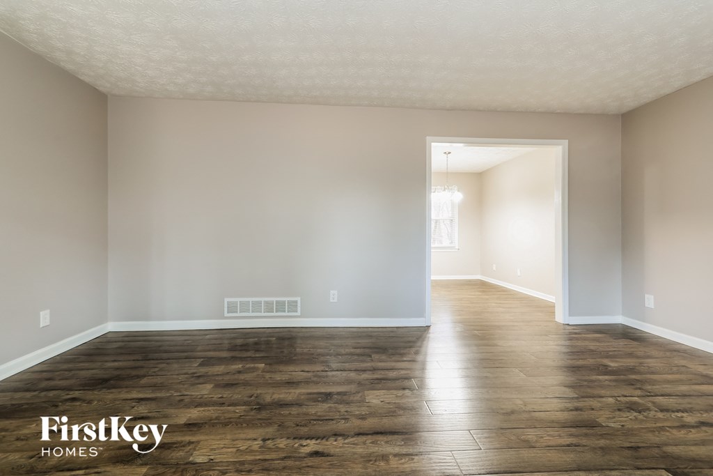 the living room and dining room of an empty house with wood floors