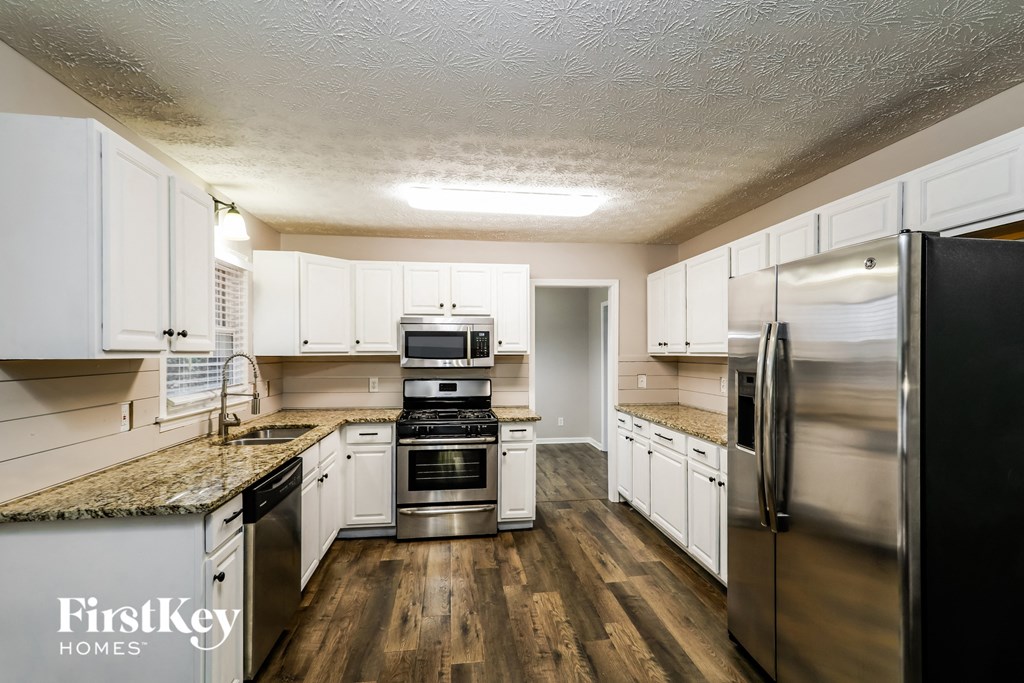 a kitchen with white cabinets and stainless steel appliances
