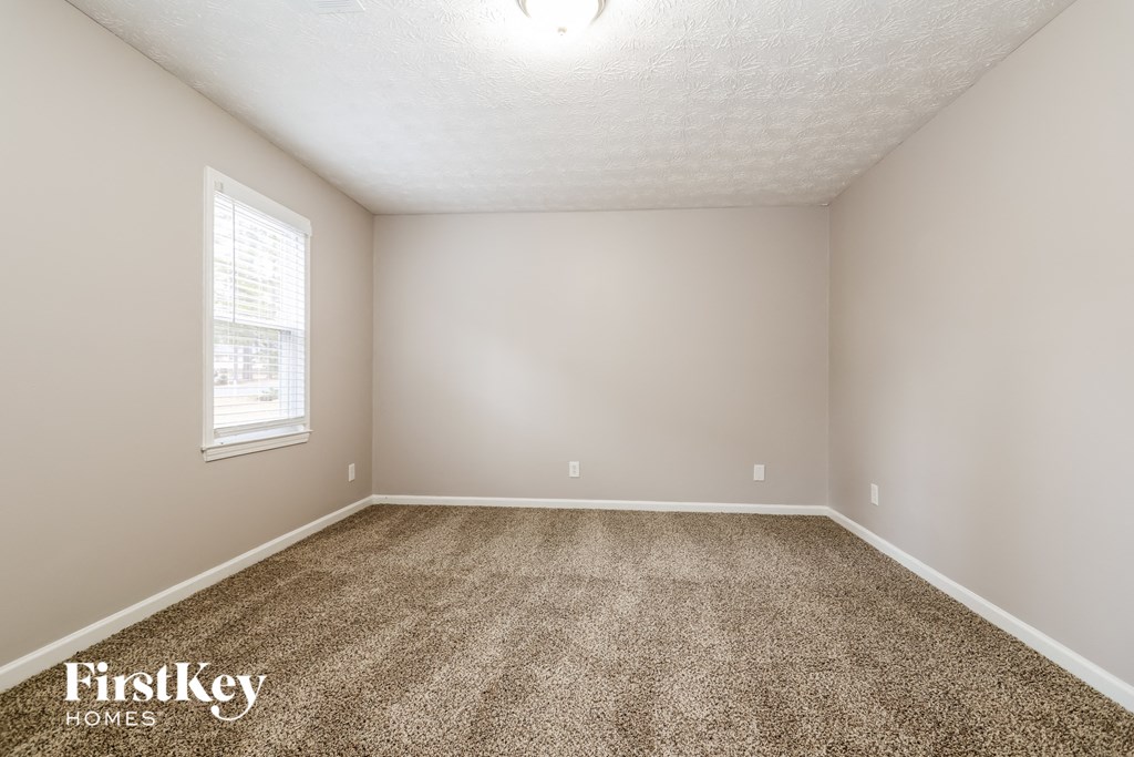 an empty room with carpet and a window