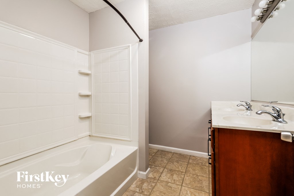 a bathroom with a tub and a sink and a mirror
