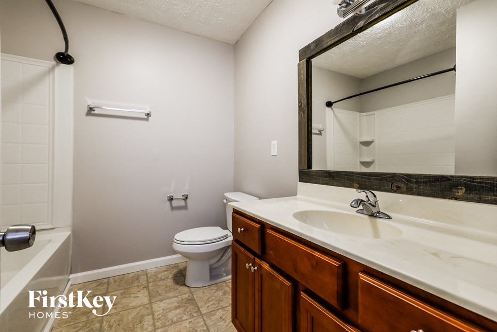 a bathroom with a toilet and a sink and a mirror