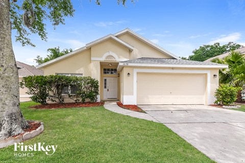 a beige house with a driveway and a garage door