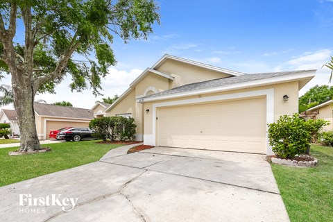 a beige house with a driveway and a garage door