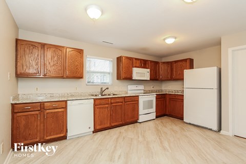 A kitchen with wooden cabinets and white appliances.