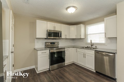 A kitchen with white cabinets and a stainless steel dishwasher.