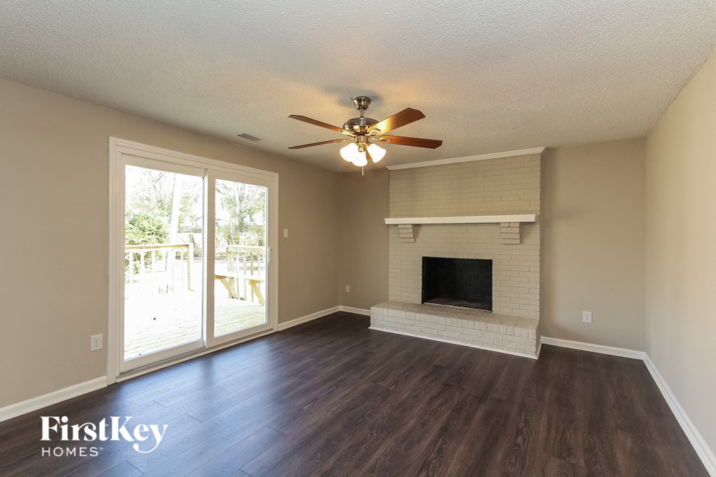 A spacious living room with a fireplace and sliding glass doors.
