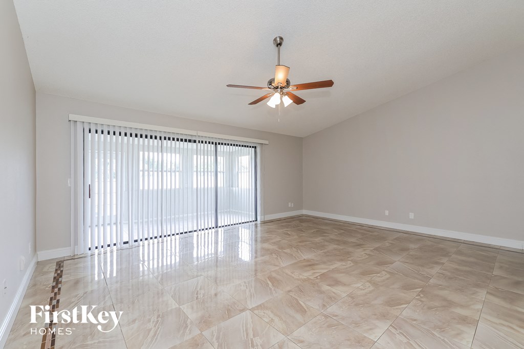 a living room with a large window and a ceiling fan