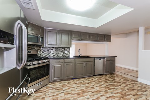 a kitchen with stainless steel appliances and a wooden floor