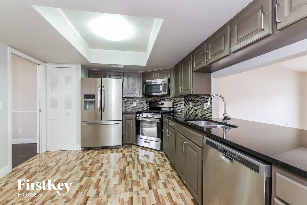 a kitchen with stainless steel appliances and wood flooring