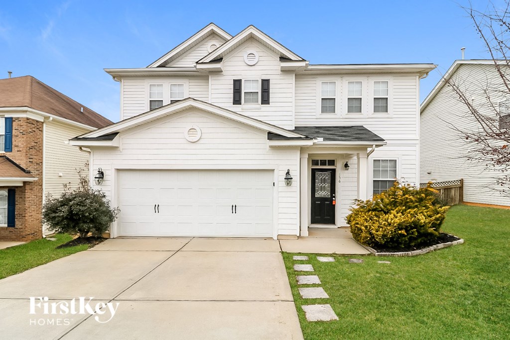 a white house with a driveway in front of it