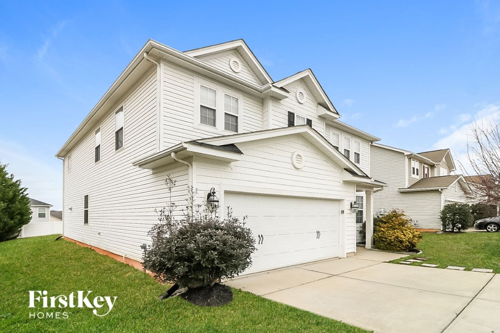 a white house with a white garage door and a sidewalk