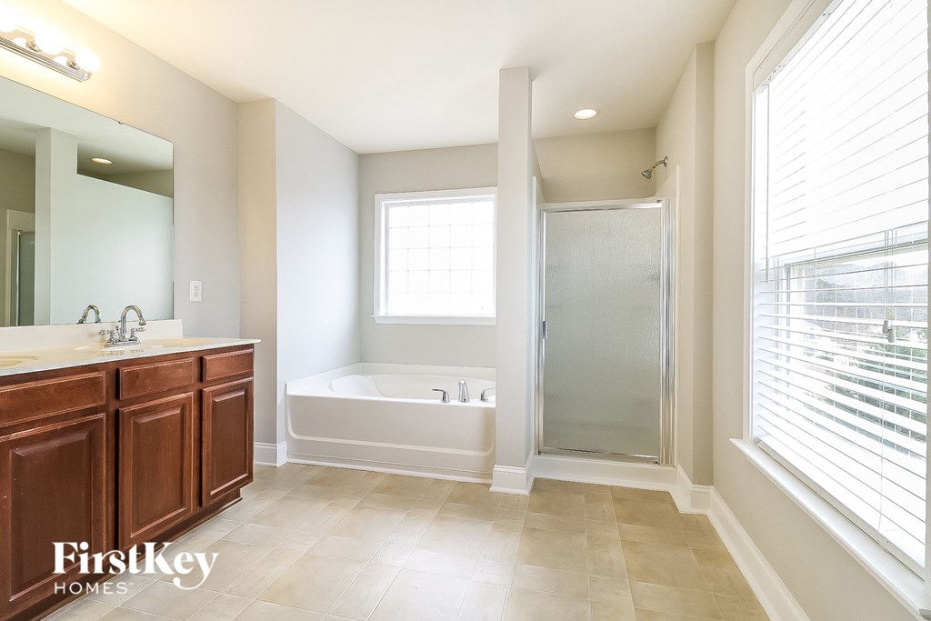 a bathroom with a tub and a shower and a sink