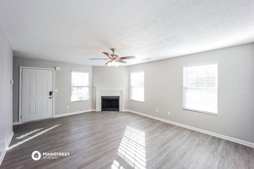 the living room with fireplace and ceiling fan