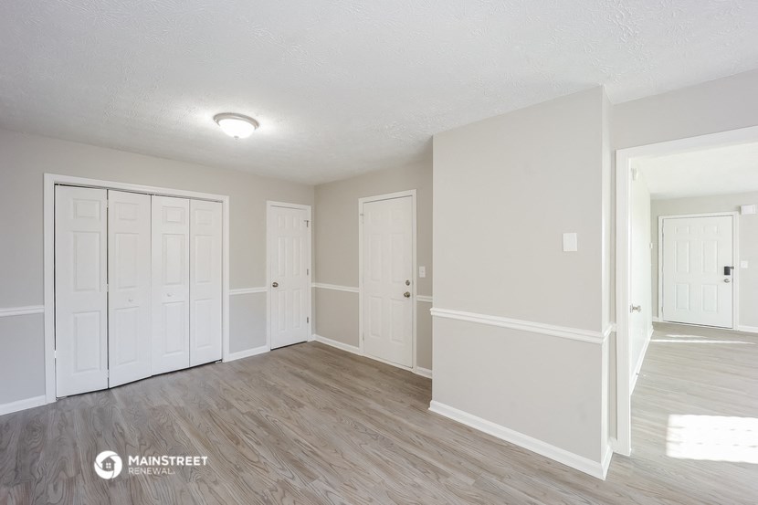 an empty living room with white walls and wood flooring