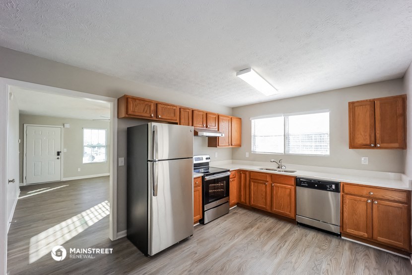 an empty kitchen with wooden cabinets and stainless steel appliances