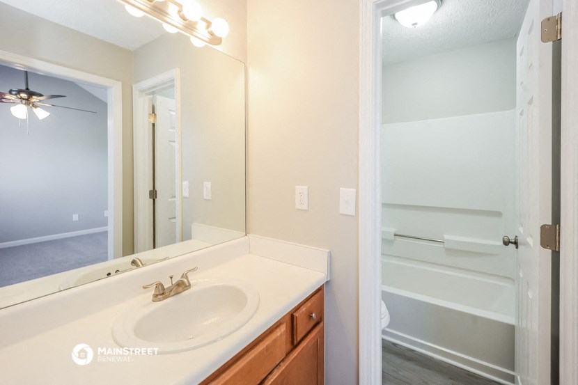 a bathroom with a sink and a mirror and a shower