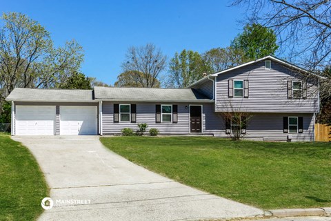 a white and gray house with a garage and a lawn