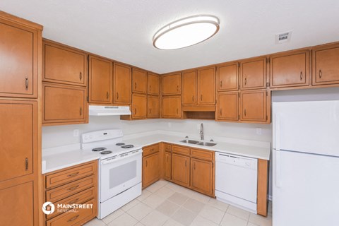 a kitchen with white appliances and wooden cabinets