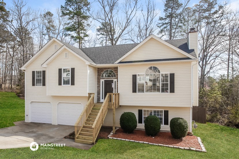 the front of a white house with a porch and stairs