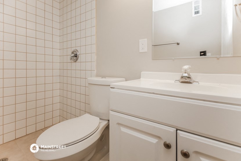 a white bathroom with a toilet and a sink