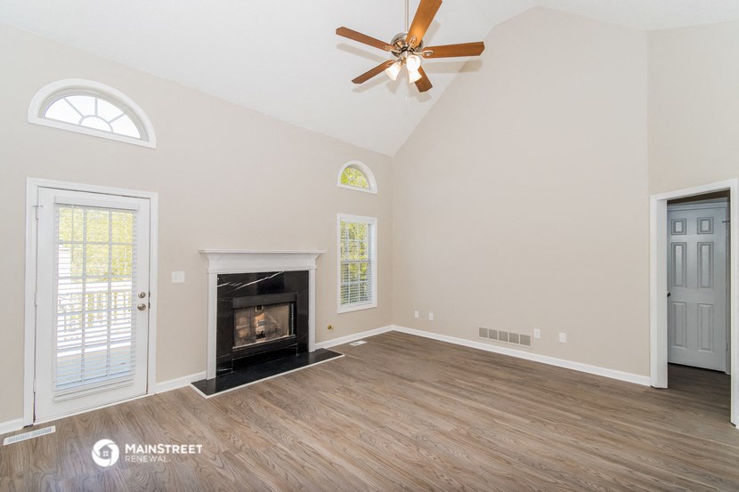 a living room with a fireplace and a ceiling fan