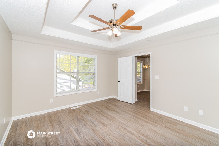 the living room of an empty house with a ceiling fan