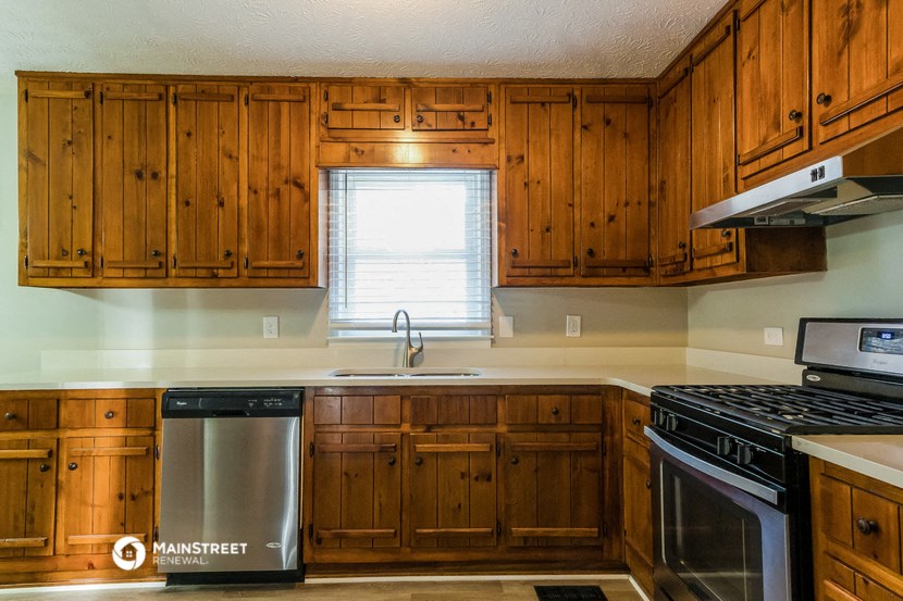 a kitchen with wooden cabinets and a stove and a sink