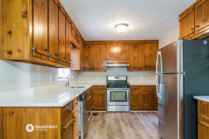 a kitchen with wooden cabinets and stainless steel appliances
