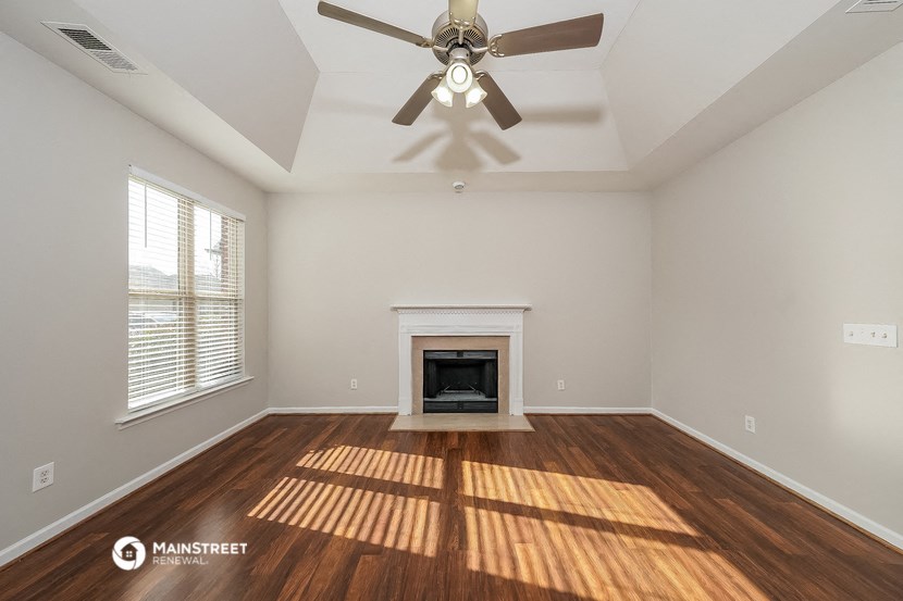 the living room with fireplace and ceiling fan