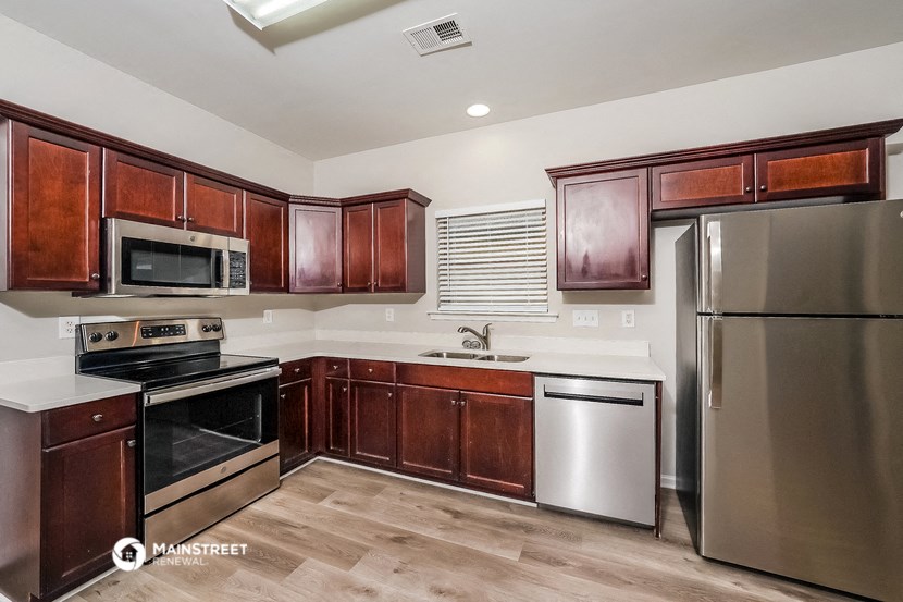 a kitchen with wooden cabinets and stainless steel appliances
