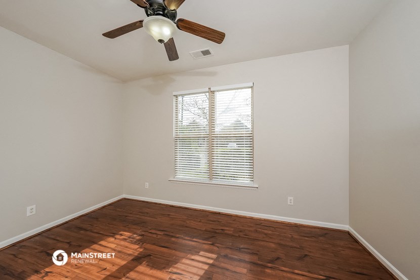 the bedroom with hardwood flooring and a ceiling fan