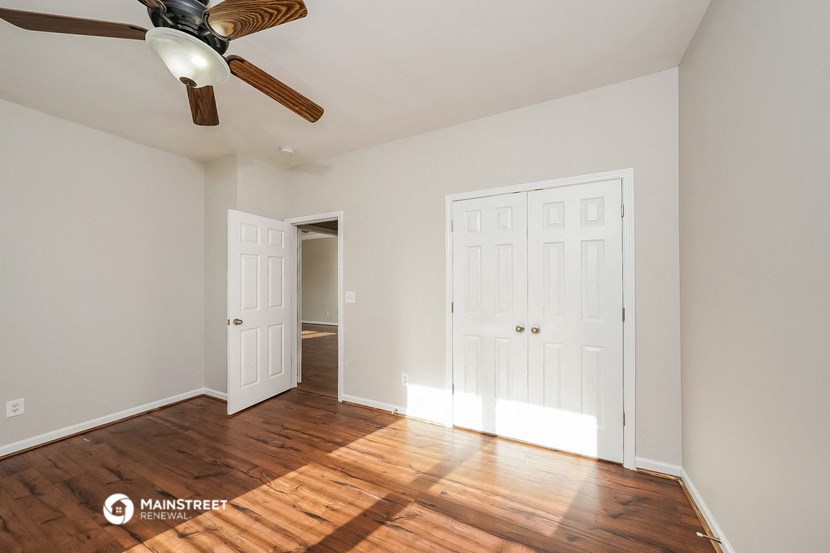 a bedroom with two closets and a ceiling fan