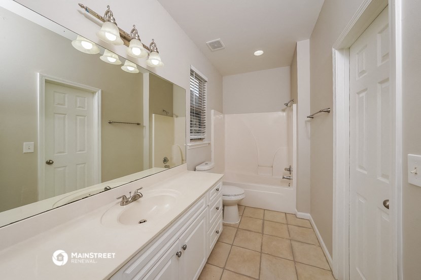 a bathroom with a large mirror and a sink and a toilet