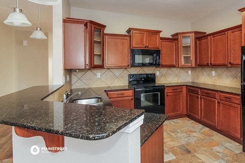 a kitchen with granite counter tops and wooden cabinets