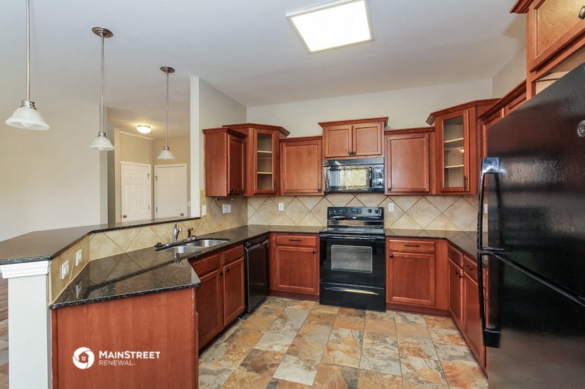 a kitchen with wooden cabinets and black appliances and a sink