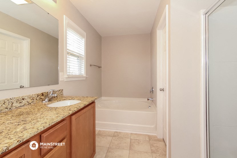 a bathroom with a sink and a shower and a bath tub