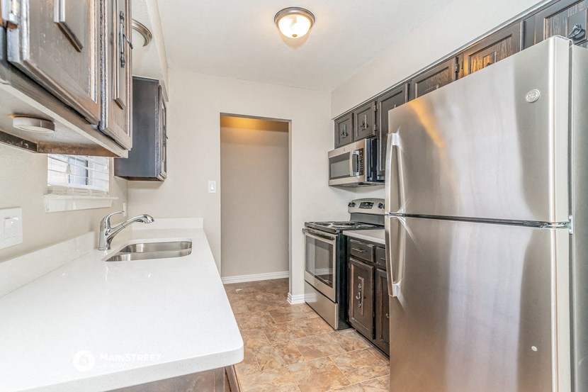 a kitchen with stainless steel appliances and white counter tops