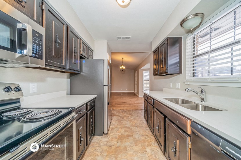 the kitchen has stainless steel appliances and a large window