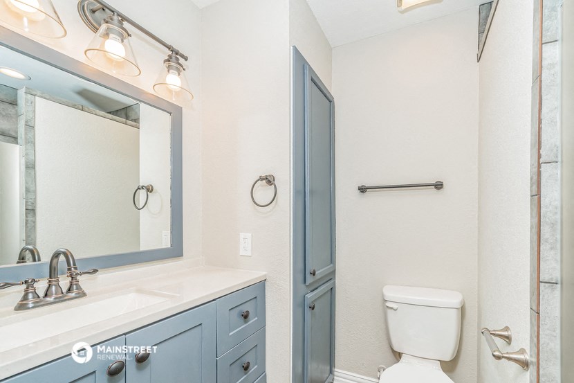 a bathroom with a toilet and a sink and a mirror
